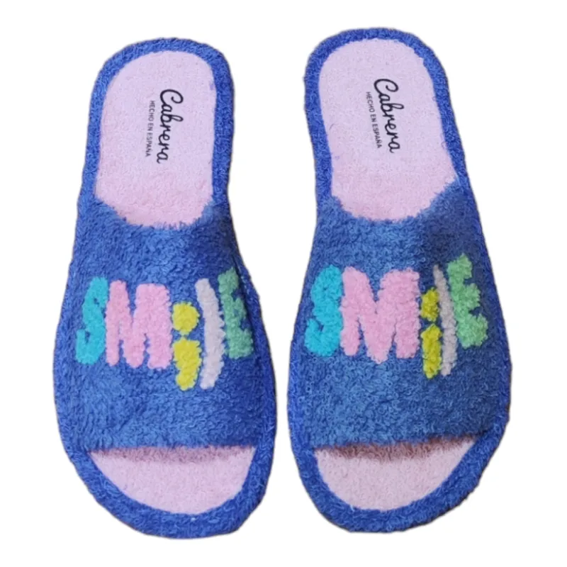 Zapatillas casa de verano con la puntera abierta fabricadas en toalla azul con la palabra smile
